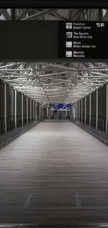 Modern airport walkway with steel beams and illuminated signs.