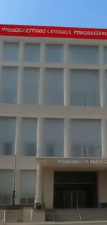 Modern building with glass facade under a clear blue sky.