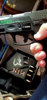 Close-up of a sleek black handgun and ammunition on display.