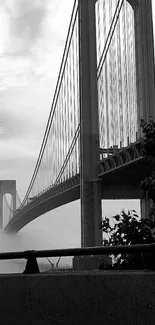 Black and white image of a bridge enveloped in mist.