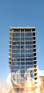 Tall glass building under a blue sky with reflections and light effects.