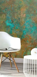 Modern chair with abstract teal wall design and round table.