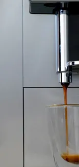 Espresso machine pours rich coffee into a clear cup against a silver background.