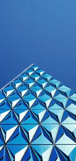 Geometric pattern on a blue building under a clear sky, perfect for wallpapers.