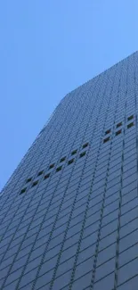 A sleek glass skyscraper reaching into the blue sky.