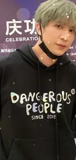 Person wearing a 'Dangerous People' hoodie at an event.