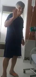 A patient waves hello in a modern hospital room.