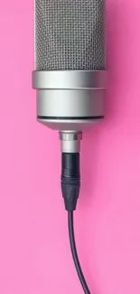 Sleek microphone on vibrant pink background.