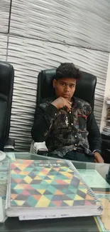 Young man seated at an office desk with notes.