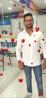 Man in white shirt at a mobile phone store with tech displays.