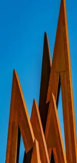 Modern rusty metal sculpture against blue sky.