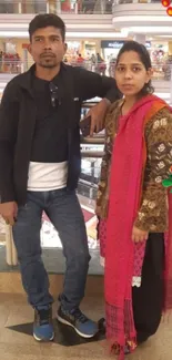 A couple standing in a shopping mall decorated with festive elements.