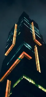 Tall skyscraper glowing at night with a dark blue sky backdrop.