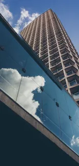 Skyscraper reflecting in glass under clear blue sky.