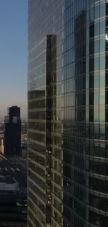 Modern skyscraper with glass facade during sunset.