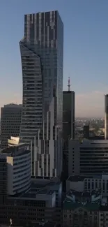 Futuristic skyscraper against a clear blue sky with urban surroundings.