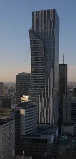 Modern skyscraper towering over the city skyline at dusk.