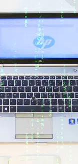 Sleek laptop on white desk with mouse, open book, and a small plant.