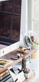 Stylish desktop with iMac and organized accessories by a window.