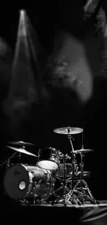 Black and white drum kit on stage with spotlight.