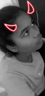 Black and white portrait of a girl with red neon devil horns.