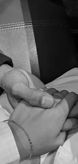 Black and white image of hands holding each other, symbolizing friendship and love.