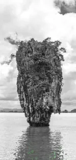 Monochrome image of an island landscape with rocky cliffs and cloudy sky.