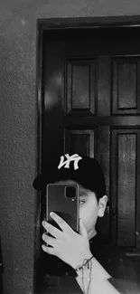 Monochrome mirror selfie with a cap.