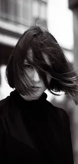 Monochrome portrait of a person with a windswept bob haircut, exuding mystery.