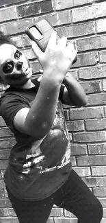 Black-and-white photo of a person taking a selfie with face paint and brick wall.