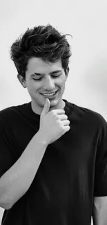 Black and white portrait of a smiling young man in a dark shirt.