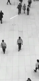 Monochrome urban scene with walking people on a tiled floor.