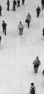 Monochrome urban scene with pedestrians on a spacious white walkway.