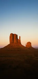 Sunset over Monument Valley with vibrant blue and orange sky.