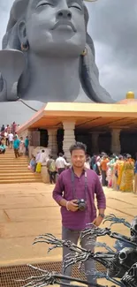 Majestic stone monument with tourists and cloudy sky in the background.