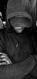 Moody black and white photo of a person in a hoodie at night.