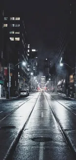 Night view of a wet city street illuminated by streetlights.