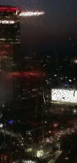 Raindrops on a window overlooking illuminated city at night.