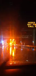 Night road scene with emergency lights reflecting on wet asphalt.