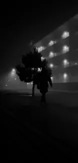 Silhouette on foggy street with building lights.