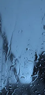 Raindrops on a glass window with a moody blue backdrop.