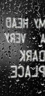 Dark rainy wallpaper with reflective text and water droplets on glass.