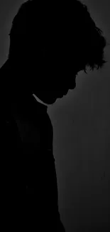 Silhouette of a person in dim light, creating a moody aesthetic.