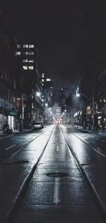 Moody urban nightscape with empty street and glowing city lights.