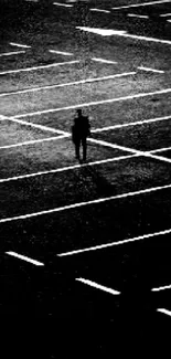 Silhouette in an empty parking lot at night.