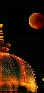 Illuminated dome with moon in night sky.