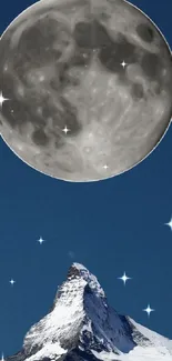 Moon above snowy mountain peak at night.