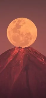 Full moon rising over a mountain peak at dusk, creating a serene and stunning view.