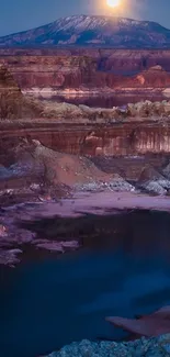 Moonlit canyon landscape with river and mountain backdrop.