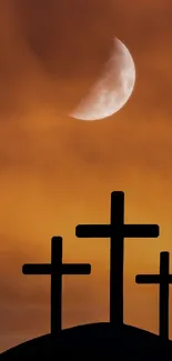 Three crosses silhouetted against an orange sky with a moon.